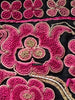 Close-up of old pink floral embroidery from Chinese minority community on black fabric